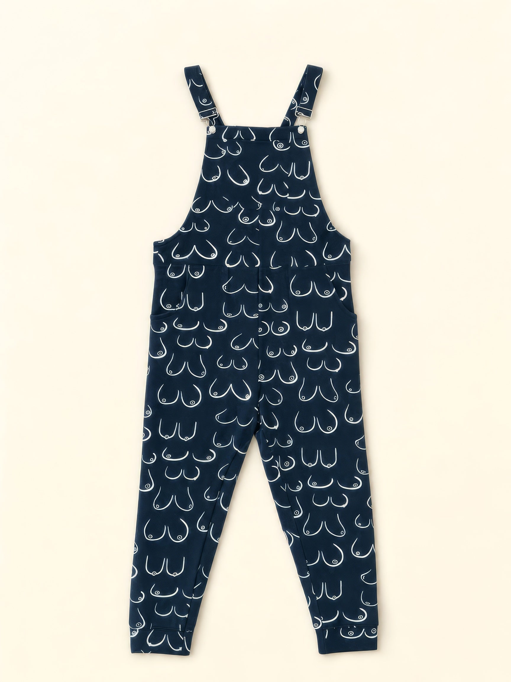 Navy Swoveralls with an all-over white hand-drawn boob print, shown flat on a cream background